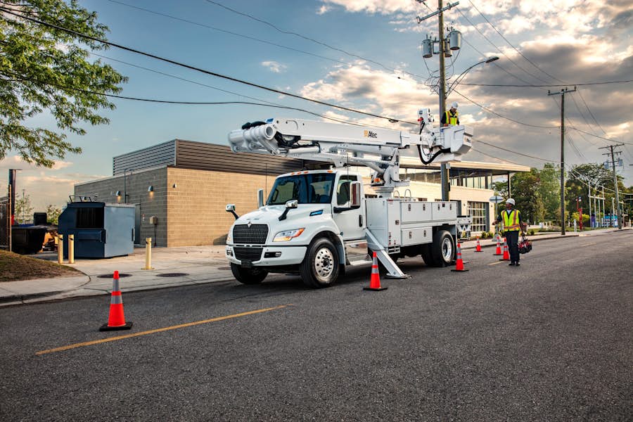 A white truck with a crane on top of it