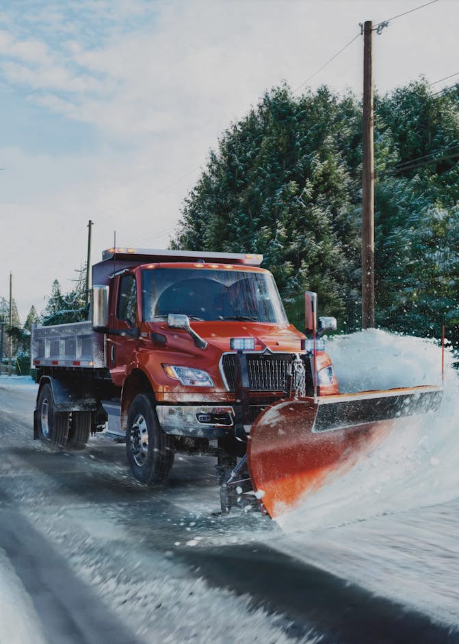 A snow plow truck on a snowy road