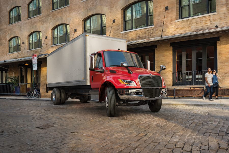A red truck parked in front of a brick building
