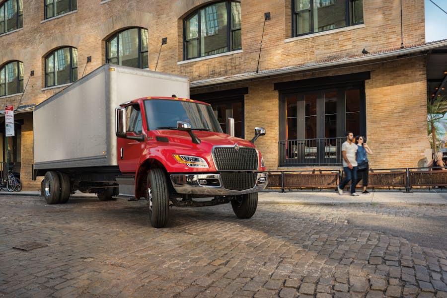 A red truck parked in front of a brick building