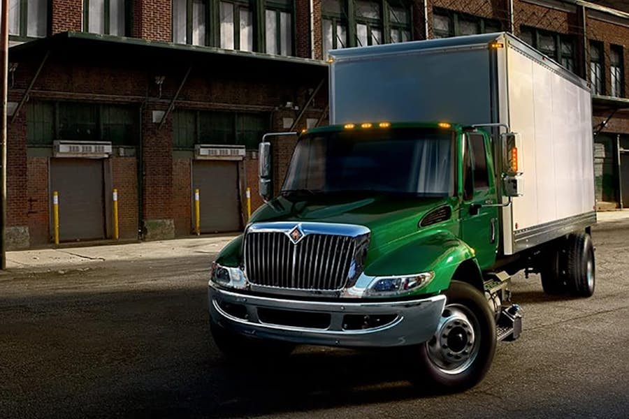 A green truck with a box on the back
