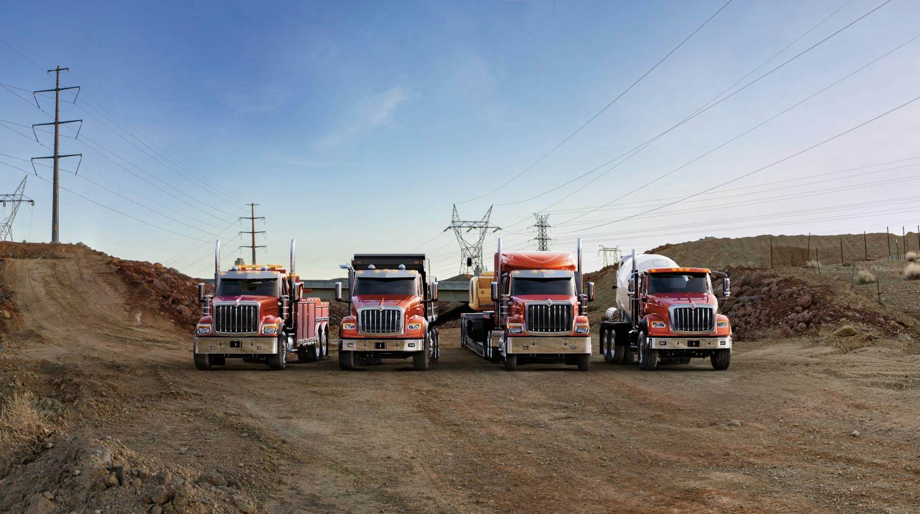 A group of trucks parked on a dirt road