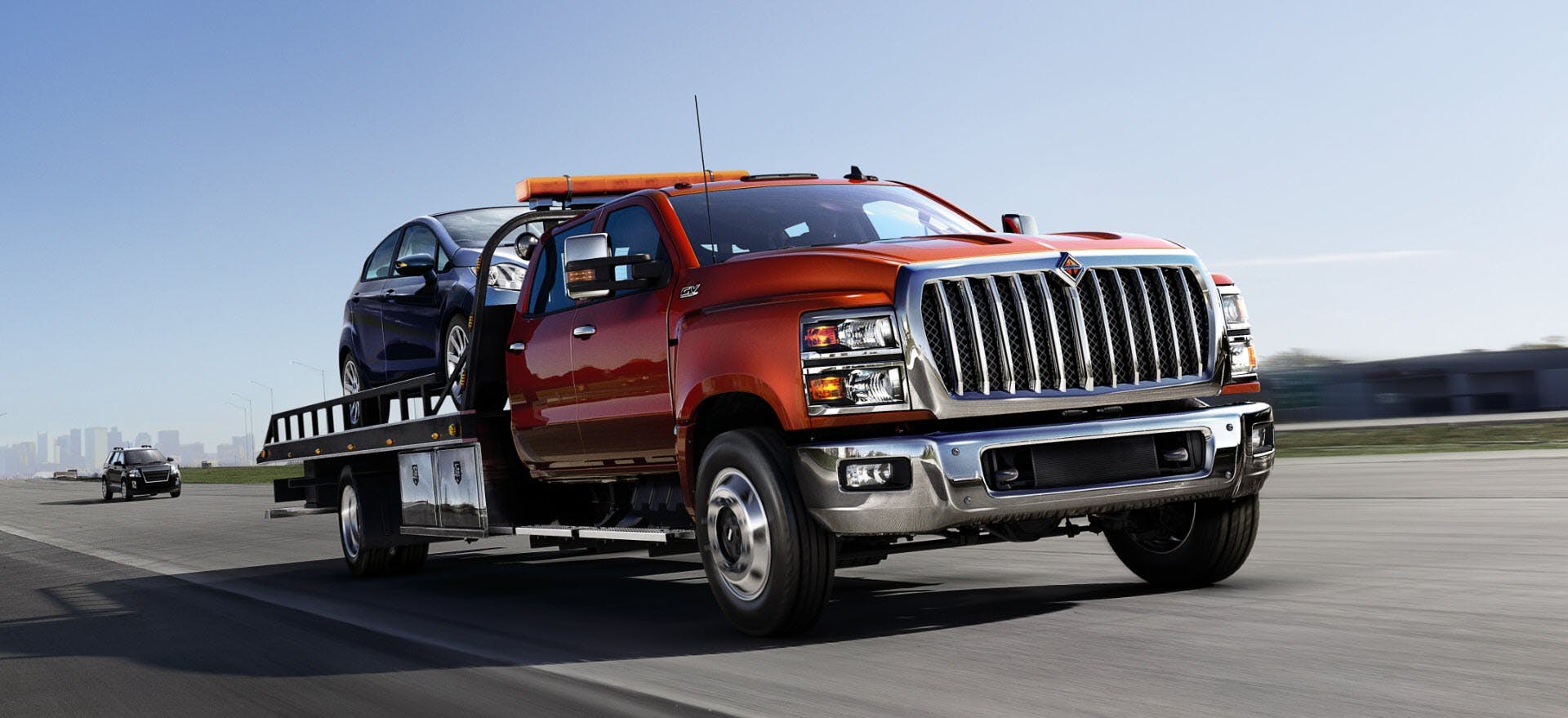 A red truck with a car on the back