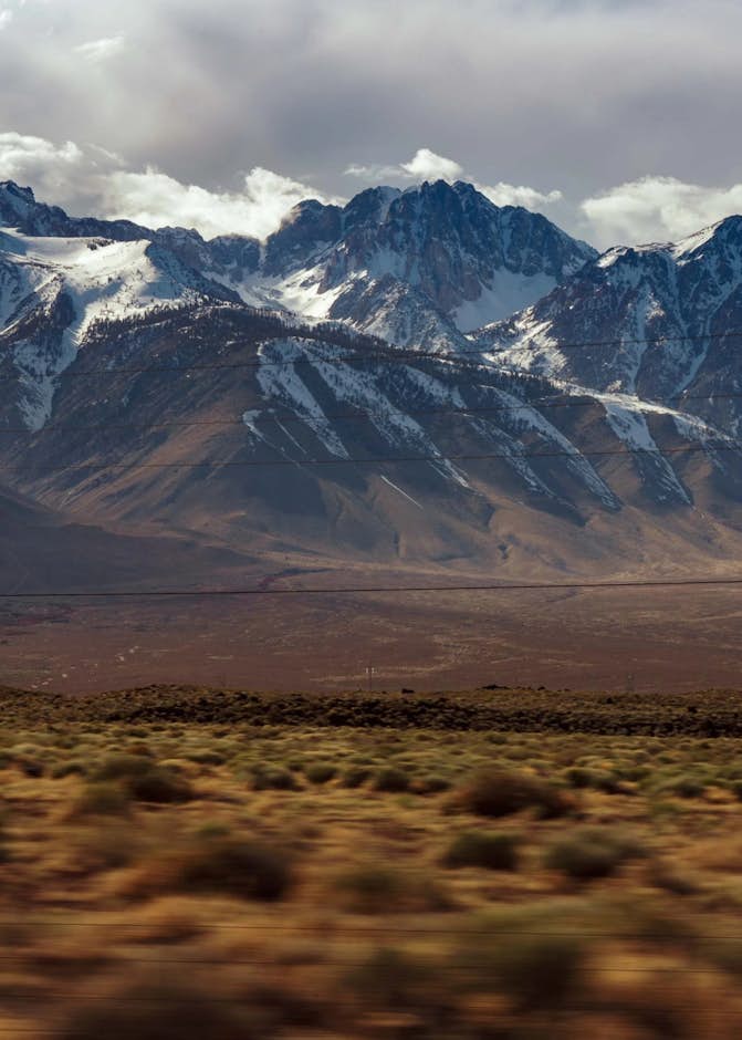 A snowy mountain range with a cloudy sky