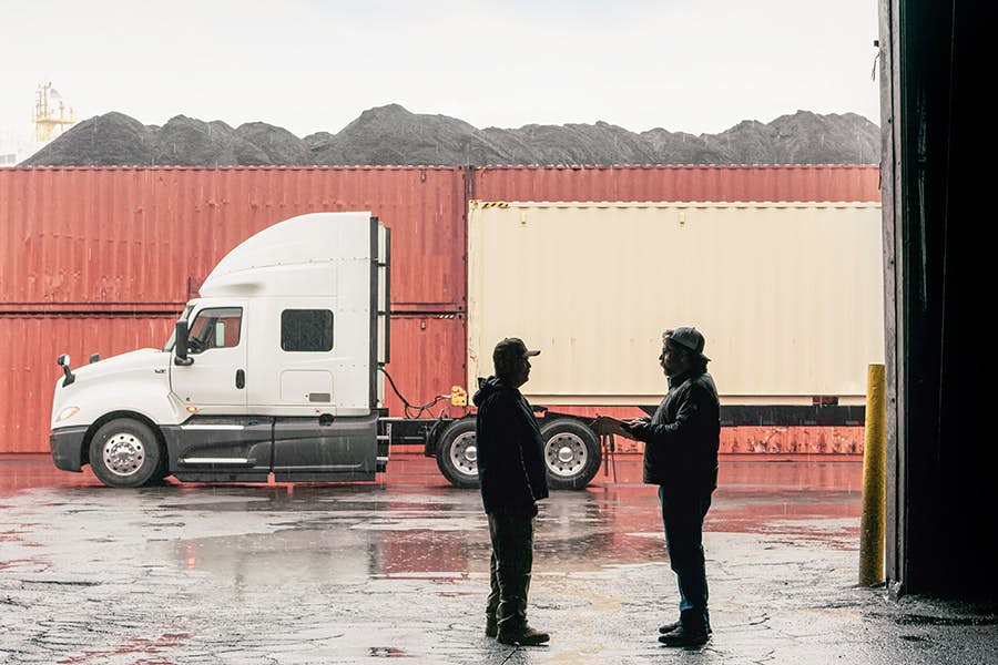 Two people standing in front of a truck