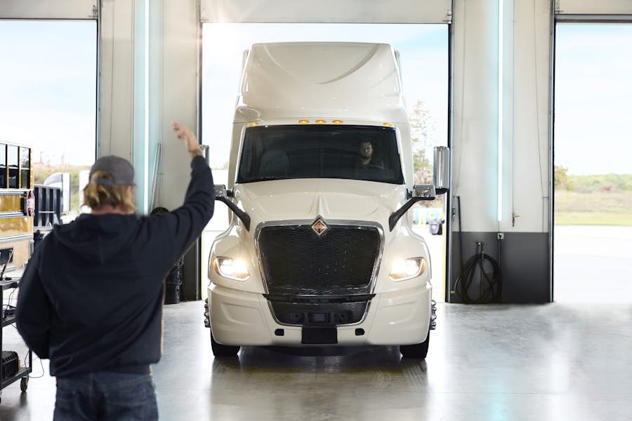 A person standing in a garage with a truck