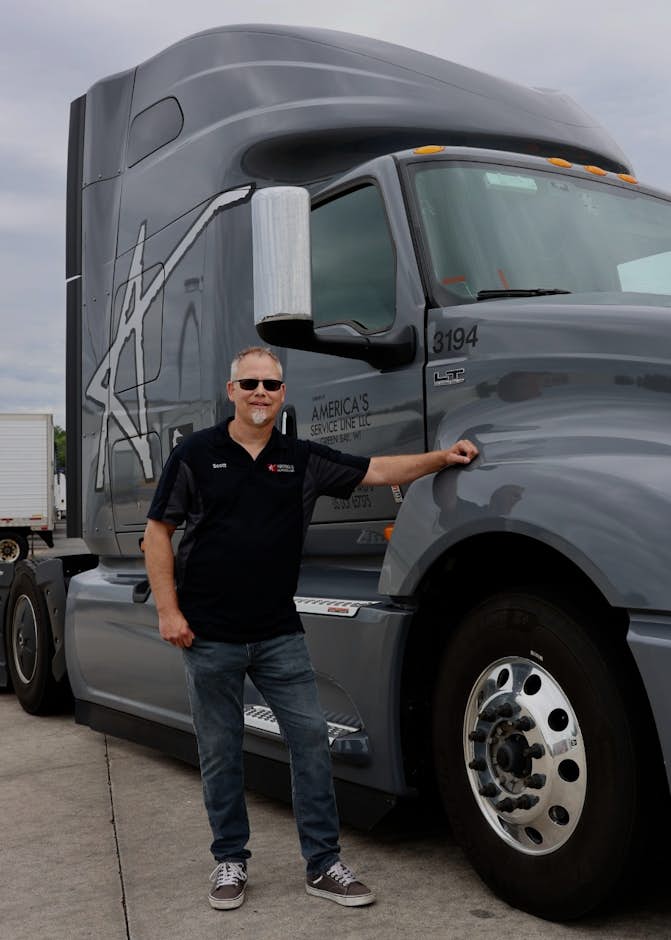 Man standing next to grey LT Series commercial truck