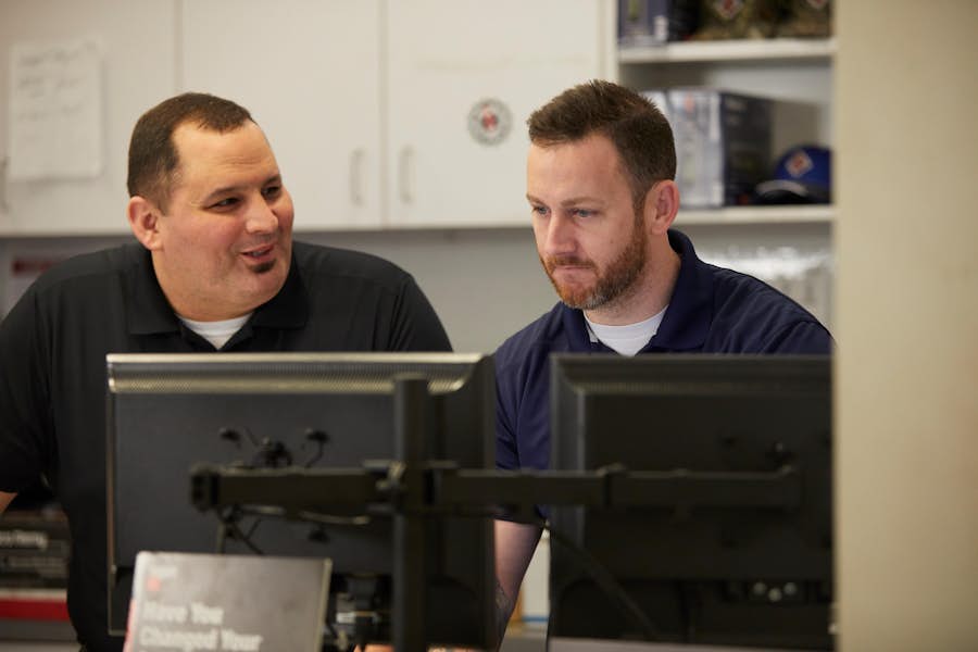 A group of men looking at computers
