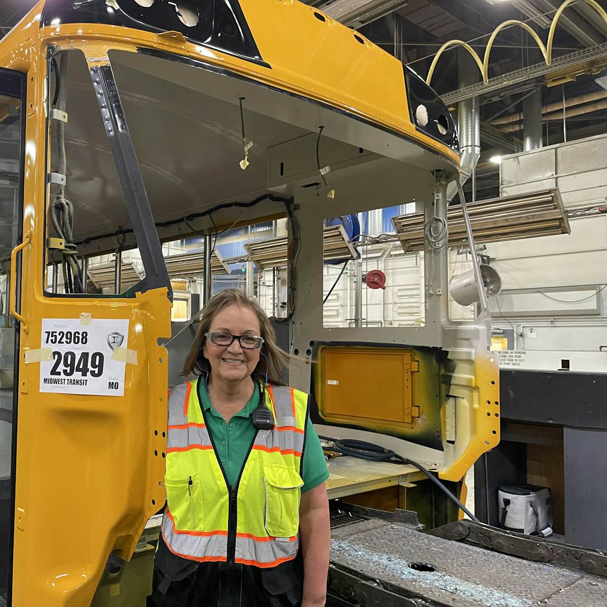 A woman standing in front of a bus frame
